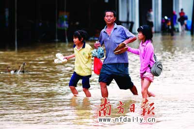 樂昌市政府前和街道被水浸,一位家長帶著孩子涉水而行?！　」攘⑤x童銅韶朱裕超攝