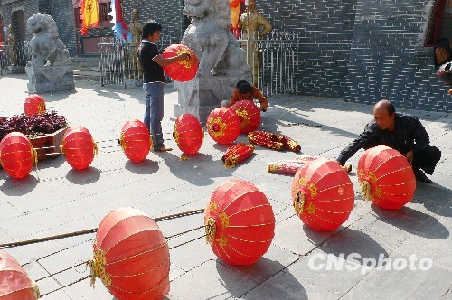 8月31日，河南省開封市天波楊府門口，工作人員在準(zhǔn)備懸掛大紅燈籠。隨著“十一”國慶節(jié)和“十一”旅游黃金周的臨近，古城開封的公園景點(diǎn)已早早開始備戰(zhàn)，營造喜慶祥和的旅游環(huán)境，迎接八方客人。 中新社發(fā) 李俊生 攝