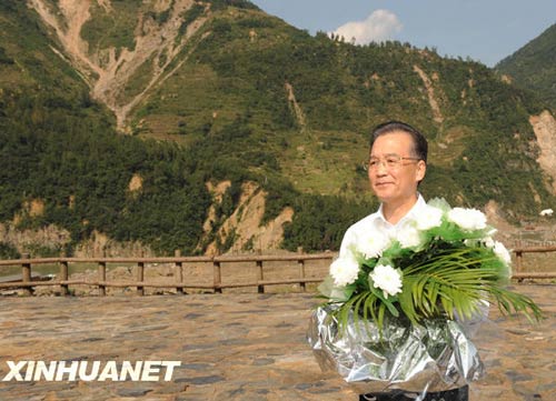 溫家寶總理十分關注災后重建進展情況。在國慶節(jié)和中秋佳節(jié)即將來臨之際，他第8次踏上了一直牽掛的這塊土地。在9月24日至26日的三天時間里，他奔波穿行于地震重災區(qū)的城鄉(xiāng)間，為節(jié)省時間，吃飯盡量安排在火車上；連續(xù)兩個晚上主持召開會議，就災后恢復重建的一系列重大問題進行研究部署。這是9月24日，溫家寶在青川縣紅光鄉(xiāng)東河口村地震遺址祭奠臺獻花。新華社記者黃敬文攝