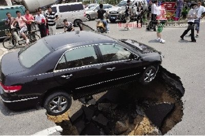 4日，南昌市昌南大道與迎賓北大道交叉口附近路面突然發(fā)生塌陷，一輛過路小轎車被卡在洞口處。圖/新華社
