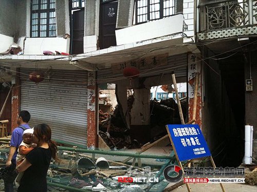 大成橋鎮(zhèn)老街，16號門面，房梁垮塌、房屋變形，門前的卷閘門已是一邊高一邊低。 圖/瀟湘晨報滾動新聞記者 劉剛