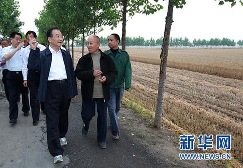 這是6月9日，溫家寶在長葛市石象鄉(xiāng)坡李王村的田間小路上與坡李王村支部書記李福成邊走邊聊。新華社記者龐興雷攝