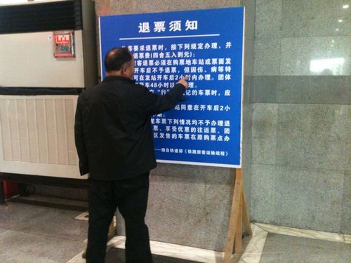 昨日，上海站，一位老人在認真研究退票新規(guī)。 李淑平 圖