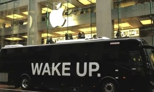 打上“醒醒吧”（Wake Up）字體的大巴車停在蘋(píng)果店門(mén)前