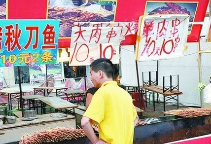 被查后，美食街上的'羊肉串'的'羊'字被涂抹了。