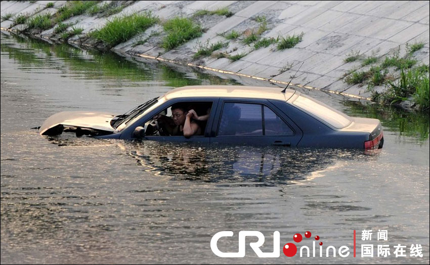 車(chē)沖入河中，依稀可見(jiàn)車(chē)中兩名男子正在打斗。