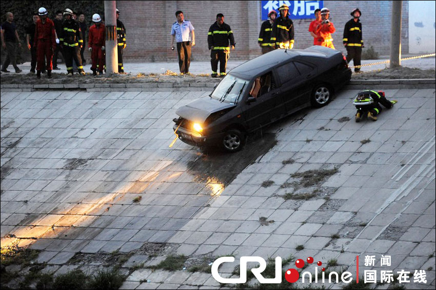 2012年6月17日下午，北京四元橋下方的西壩河輔路上，一輛轎車失控墜河中。消防員將轎車拖上岸。