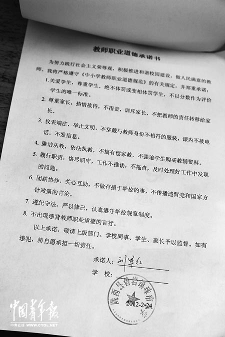 劉軍紅簽字的教師職業(yè)道德承諾書。本報(bào)記者 張鵬攝