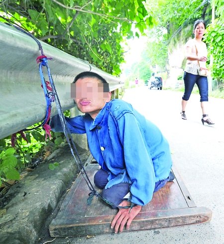 江津白沙鎮(zhèn),被捆在公路邊的何貴明。 首席記者 鐘志兵攝