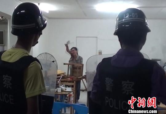 圖為涉嫌販毒的男子持菜刀在宵夜店與民警對峙。 劉志強(qiáng) 攝