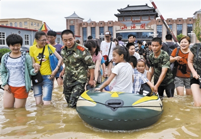 昨日，消防戰(zhàn)士在秦皇島市山海關(guān)火車站涉水運(yùn)送旅客。當(dāng)日，受持續(xù)強(qiáng)降雨影響，河北省秦皇島市海港區(qū)、山海關(guān)區(qū)等地出現(xiàn)內(nèi)澇，部分列車停運(yùn)。 新華社發(fā)