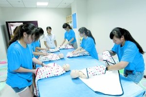 昨日，學生們正在進行給嬰兒穿衣服的訓練。