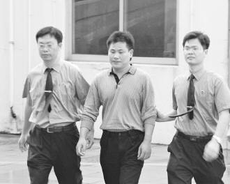 圖為陳建學(xué)被押送接受審訊。吳曉鋒攝