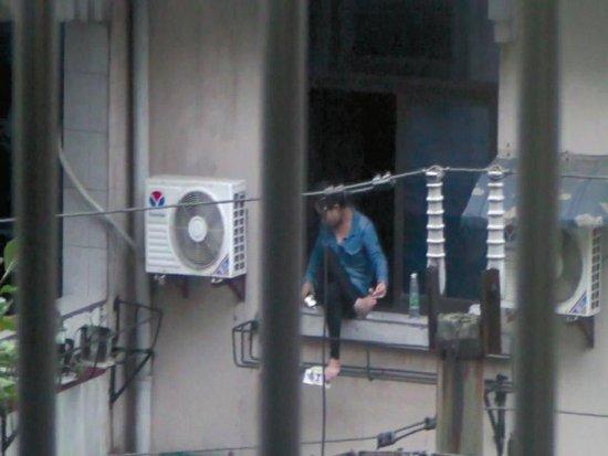 美女坐窗臺兩個多小時，不時拿起手機看幾眼，難道是要跳樓自殺？