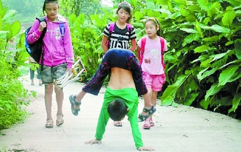 倒立行走去上學(xué) 堅(jiān)強(qiáng)癱瘓男孩感動(dòng)網(wǎng)友。圖據(jù)山東商報(bào)