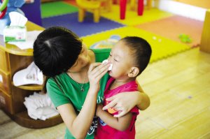 2012年9月3日，浙江一所幼兒園，老師幫孩子擦鼻涕。