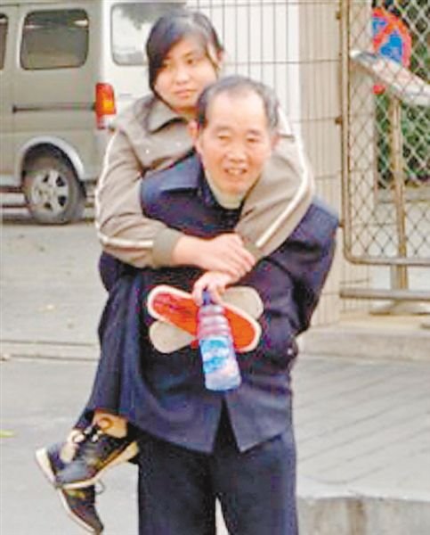 邱世祿背小娟上學(xué)。