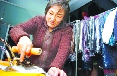 資料圖：鄒春蘭在自己洗衣店內(nèi)工作。圖片來源 揚(yáng)子晚報(bào)