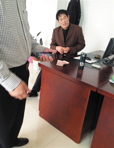 10月29日，獻(xiàn)縣國稅局稽查局辦公室內(nèi)，一名企業(yè)主交了兩萬元現(xiàn)金在桌上。新京報(bào)記者 孟祥超 攝