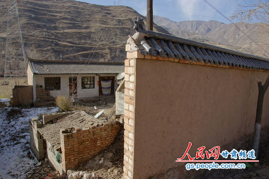 甘肅漳縣殪虎橋鄉(xiāng)東橋村的“遮羞墻”擋住農戶房屋（人民網(wǎng)記者 高翔 張鵬 隋欣 攝）