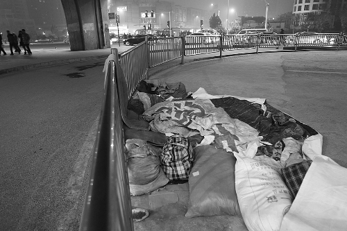 農(nóng)民工露宿地的不遠(yuǎn)處，夜幕下車來車往