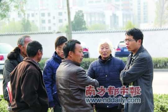 登封法院外，張海超與病人和家屬交談。在許多塵肺病友看來，張海超是一個(gè)大救星。