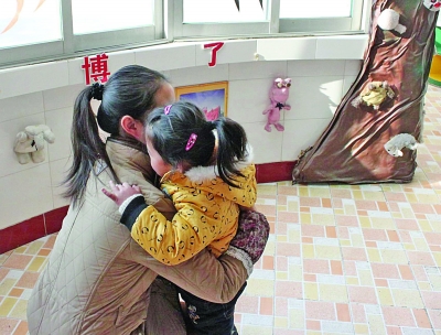 江都商貿(mào)幼兒園一位老師在擁抱該園的孩子。因?yàn)樯婕笆召M(fèi)，作為該園精品教育的一個(gè)項(xiàng)目，老師的擁抱行為也被質(zhì)疑。 董鑫 攝