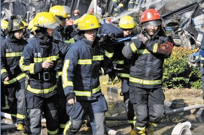消防官兵將受傷的同事抬出。陳福 攝
