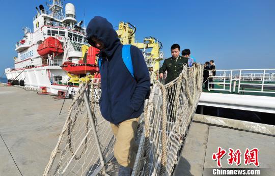 圖為24名“驢友”的“導(dǎo)游”被邊防的工作人員帶下船接受調(diào)查。 駱云飛 攝