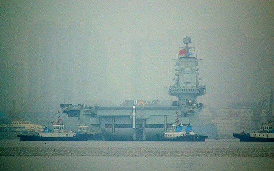 資料圖：大連港口大霧彌漫，中國首艘航母“遼寧艦”徐徐離開港口。