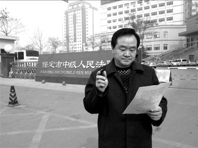焦占軍在法院門口拿著決定書，無(wú)語(yǔ)站立。京華時(shí)報(bào)記者孫思婭攝