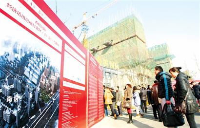 市民正在瑞海北路一處保障房前觀看樓盤公示。