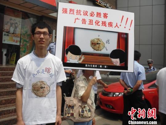 6月5日，視障人士在鄭州一必勝客門前舉牌抗議蝦球廣告歧視。 門杰丹 攝