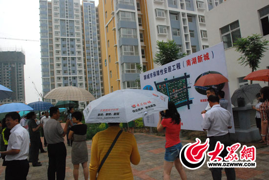 6月18日下午，西線采訪團(tuán)記者冒雨參觀了南湖新城保障房項(xiàng)目，他們?yōu)槿罕娔軐?shí)現(xiàn)安居夢而欣喜。